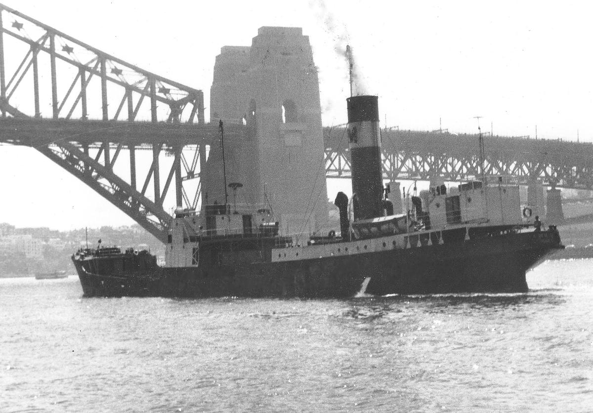 Black-and-white photo of the collier Ayrfield steaming past the Sydney Harbour Bridge in March 1969