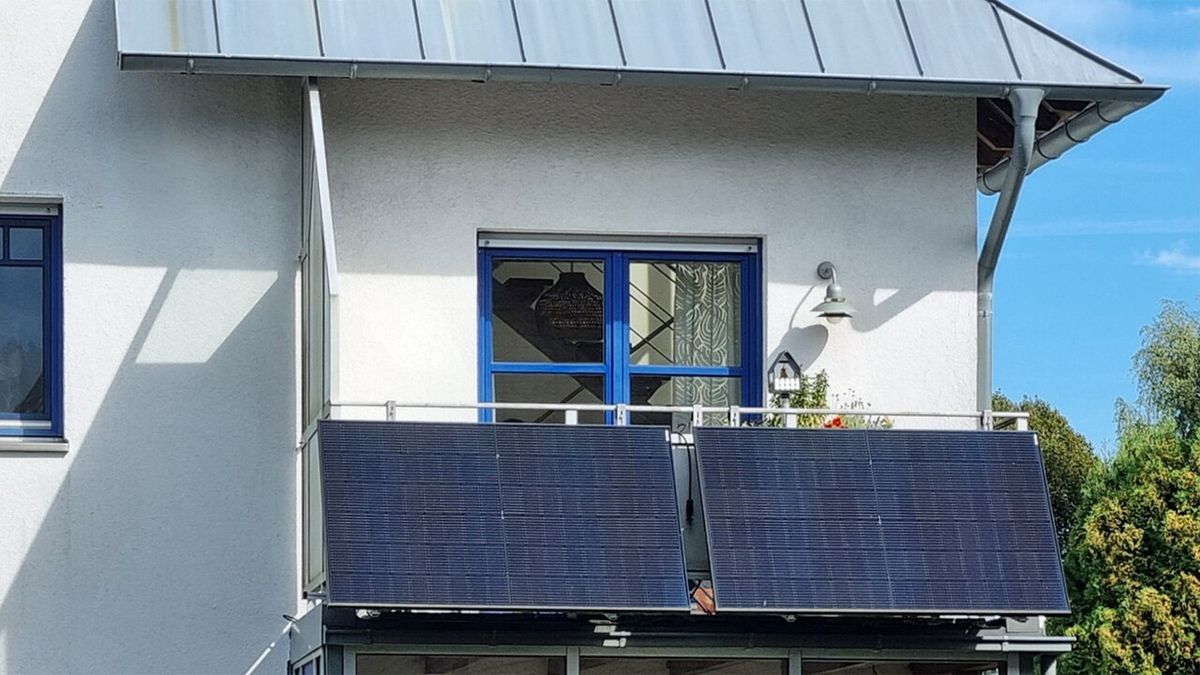 Two solar panels mounted on the railing of a house balcony in northern Germany