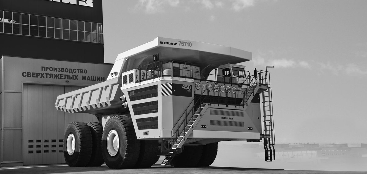 Black-and-white image of the BelAZ 75710 dump truck beside a BELAZ production hall