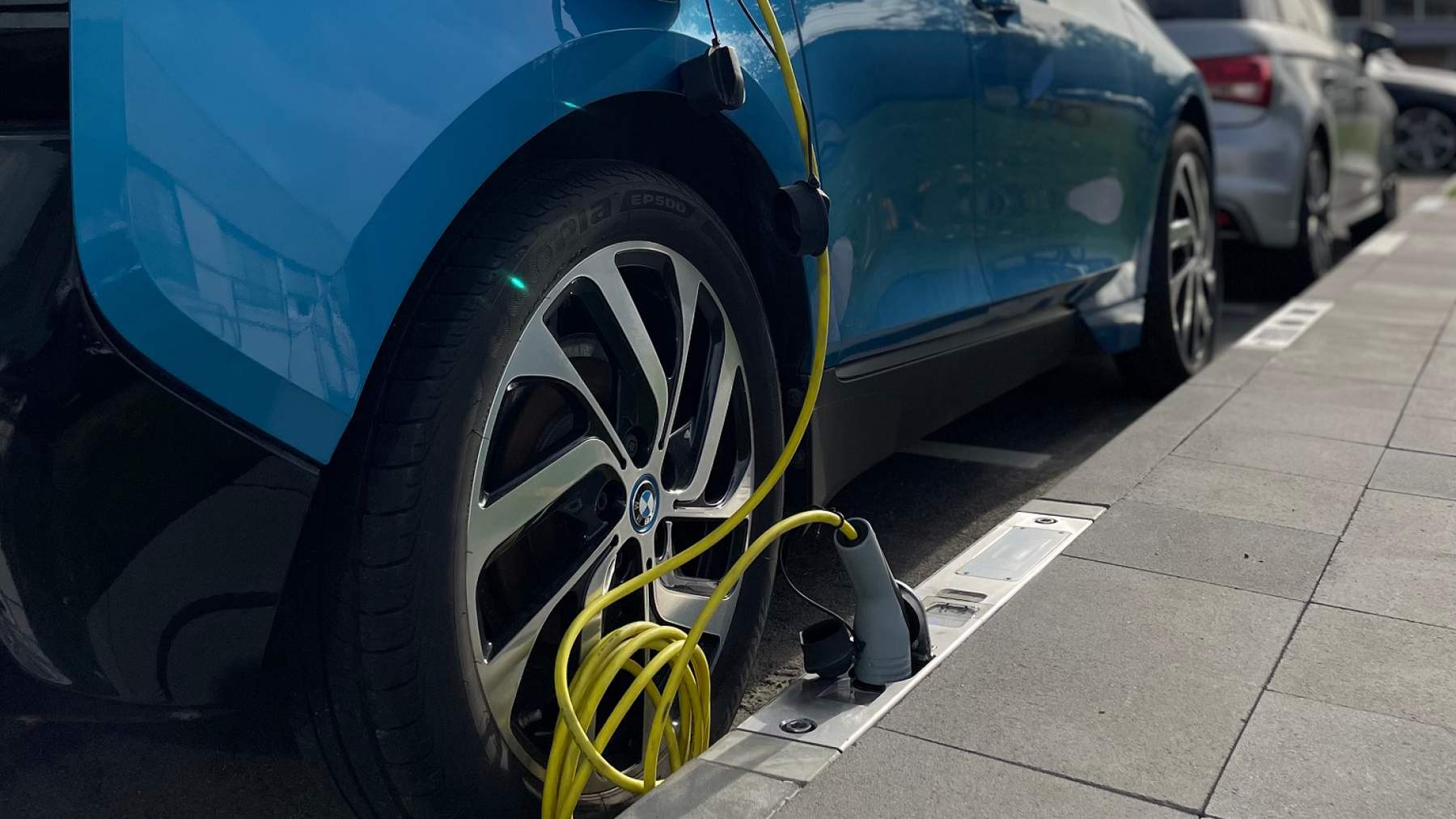 Cologne tested a curb charger that hides a 22-kilowatt EV socket inside a standard-size curbstone, logging 2,829 charging sessions with over 99 percent availability, and installation still cost about the same as a charging post