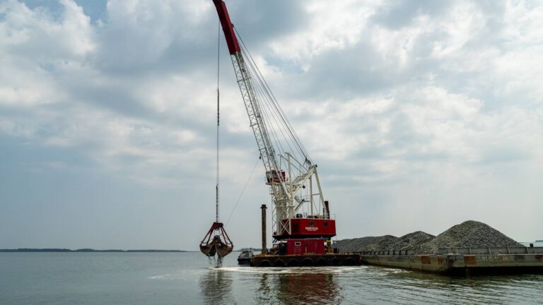 Crane on a Murtech barge dropping stone to build a Chesapeake Bay oyster reef at Hooper Strait Oyster Sanctuary, Maryland