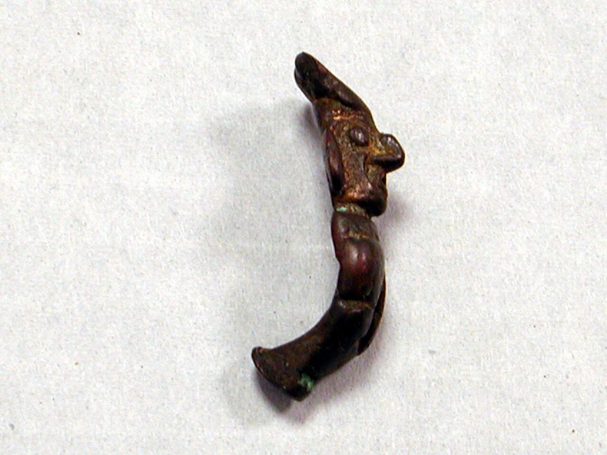A copper spear-thrower with a hook at one end, photographed against a plain background