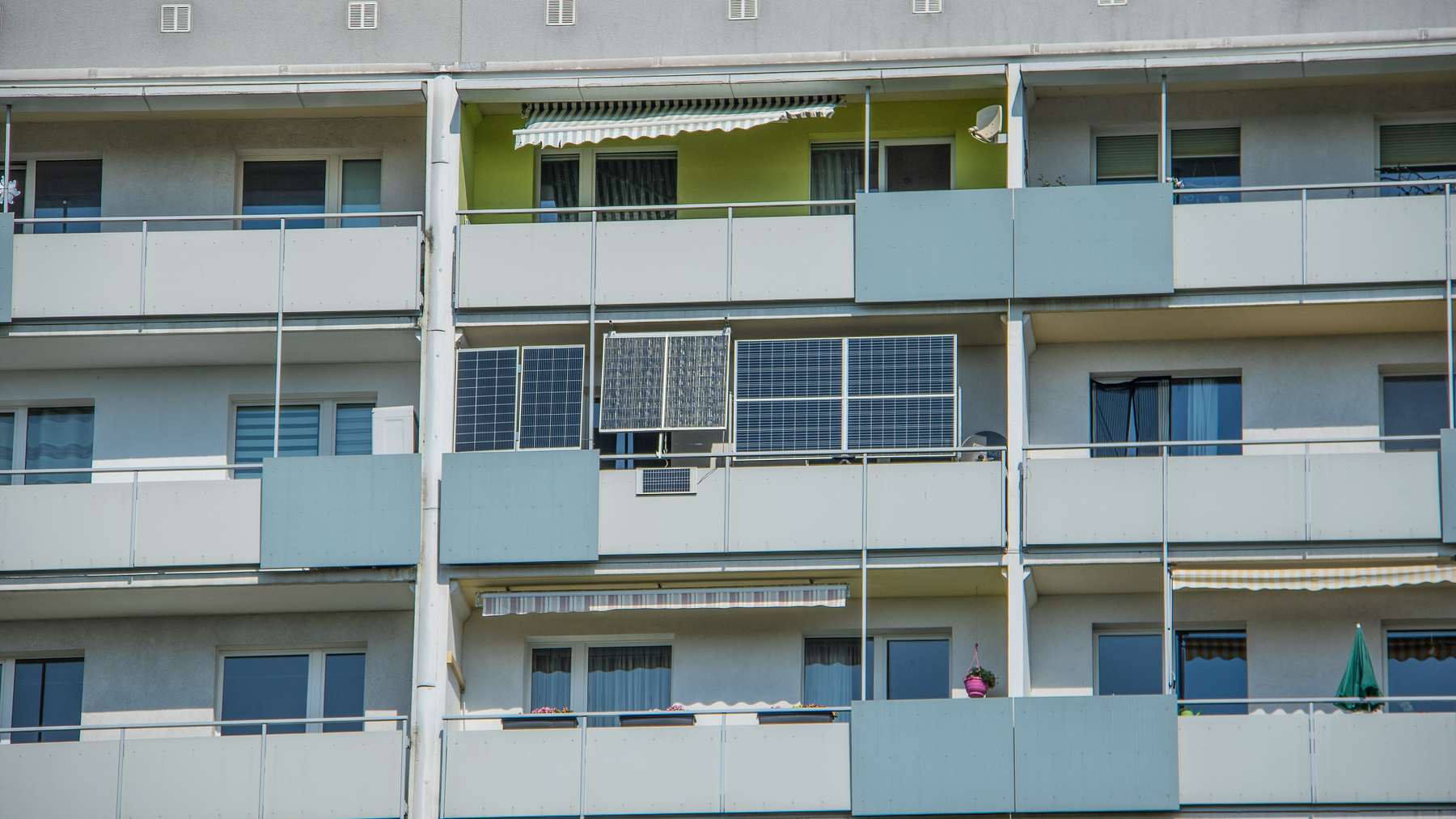 Balcony solar systems hanging from the railing of an apartment block in Leipzig, Germany