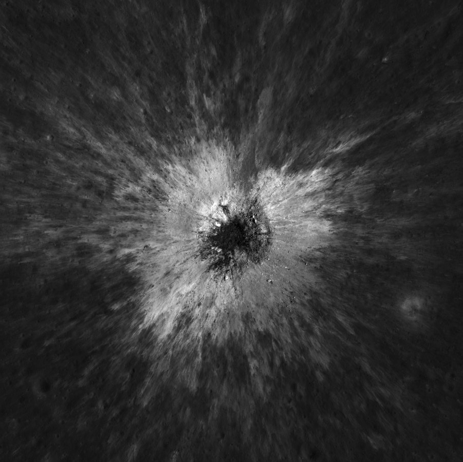 Overhead view of McGetchin crater, a dark hole ringed by bright ejecta streaks on the Moon
