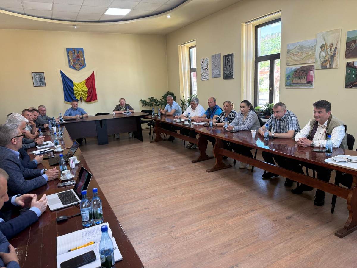 MPI Magnesium representatives and Rășinari local councillors seated around tables during a meeting
