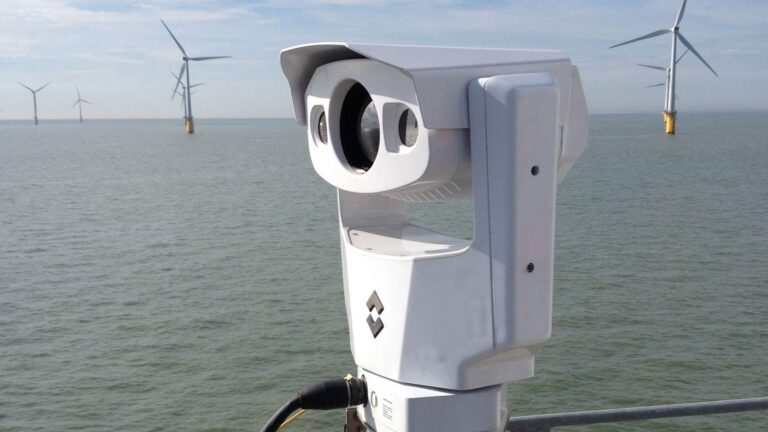 Thermal camera of the type used to record seabird collisions, mounted on an offshore wind turbine with turbines behind it
