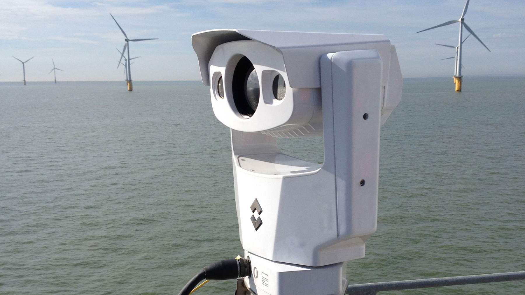 Thermal camera of the type used to record seabird collisions, mounted on an offshore wind turbine with turbines behind it