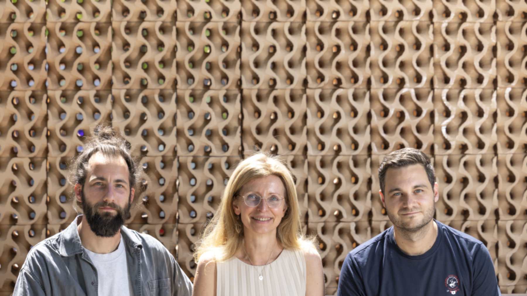 Julian Jauk, Milena Stavric and Kristijan Ristoski in front of the TU Graz ceramic cooling wall made of 3D-printed clay cubes