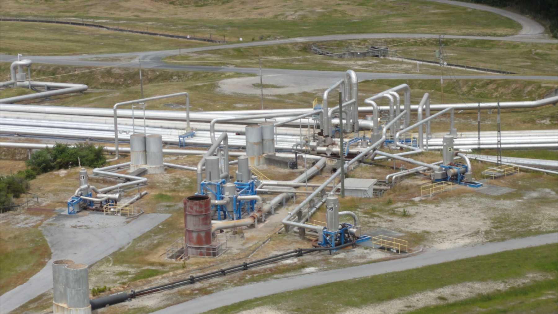 Pipes, separators and buildings of the Wairakei geothermal power plant seen from a lookout in New Zealand