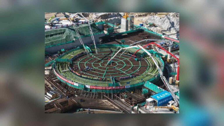 Workers line the rebar grid of the Unit 2 reactor building foundation at the Zhaoyuan nuclear plant as concrete pump booms start the first pour