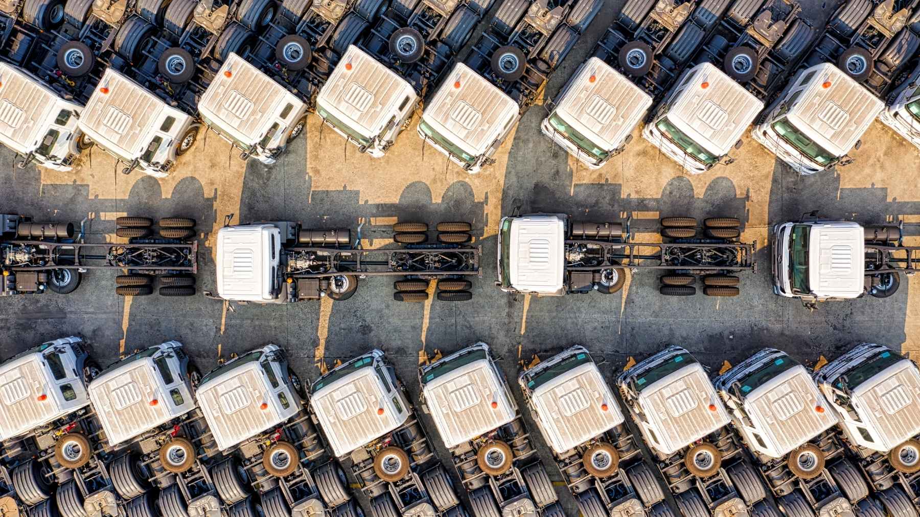 Camiones de transporte pesado alineados en una plataforma logística, símbolo del fin del diésel y la electrificación del transporte en Europa