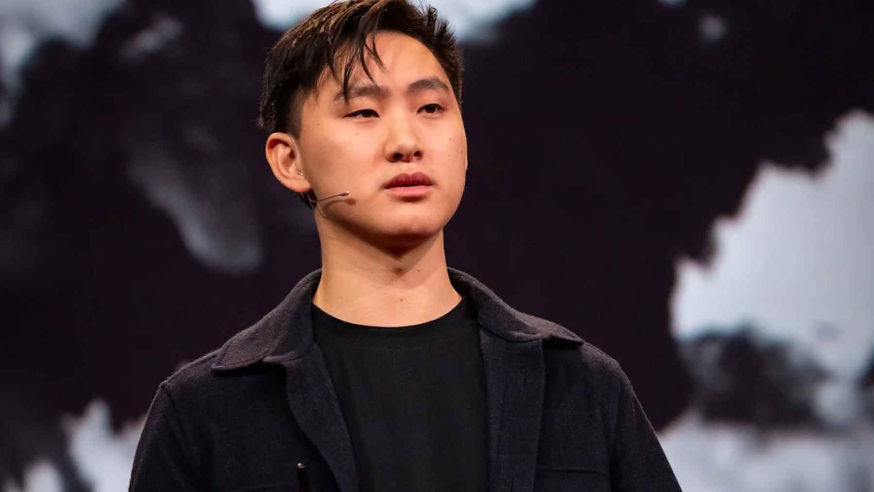 Ponente con micrófono de diadema hablando sobre inteligencia artificial en un escenario