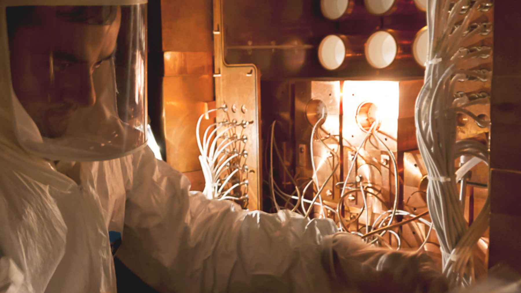 Investigador con traje de protección revisa el detector COSINE-100 en un laboratorio subterráneo de Corea