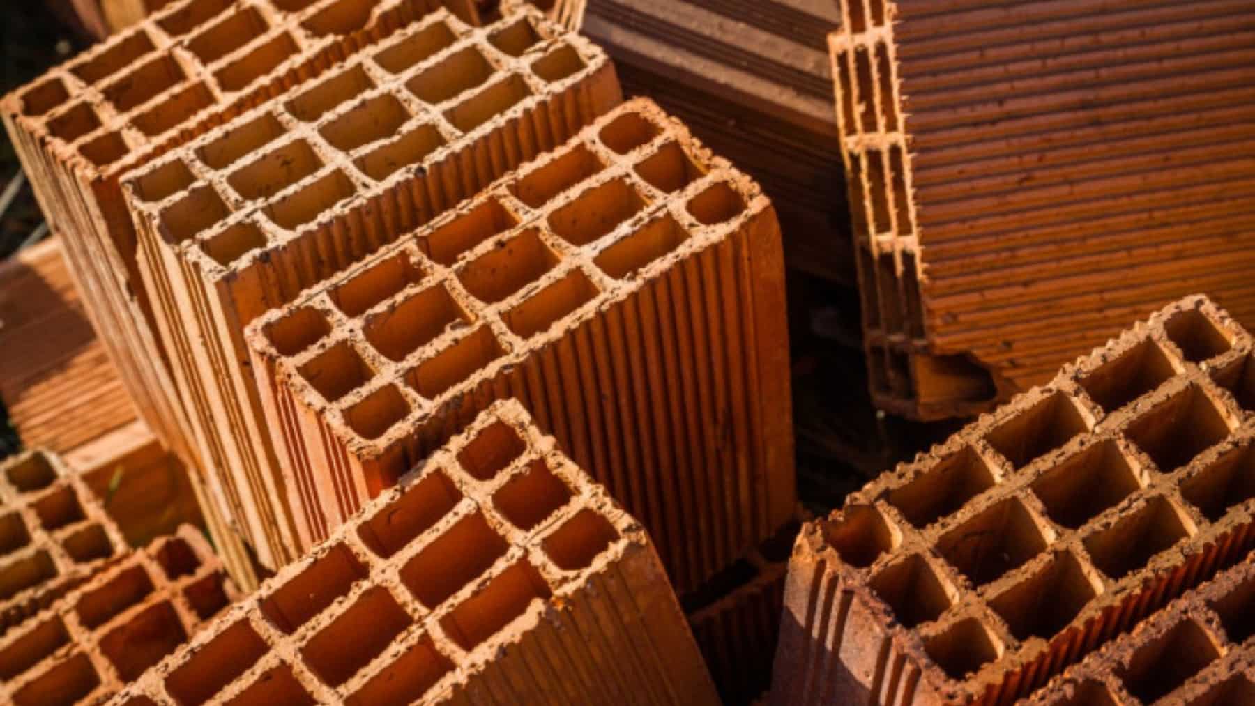 Primer plano de varios ladrillos huecos cerámicos apilados, usados como material de construcción para muros y tabiques.