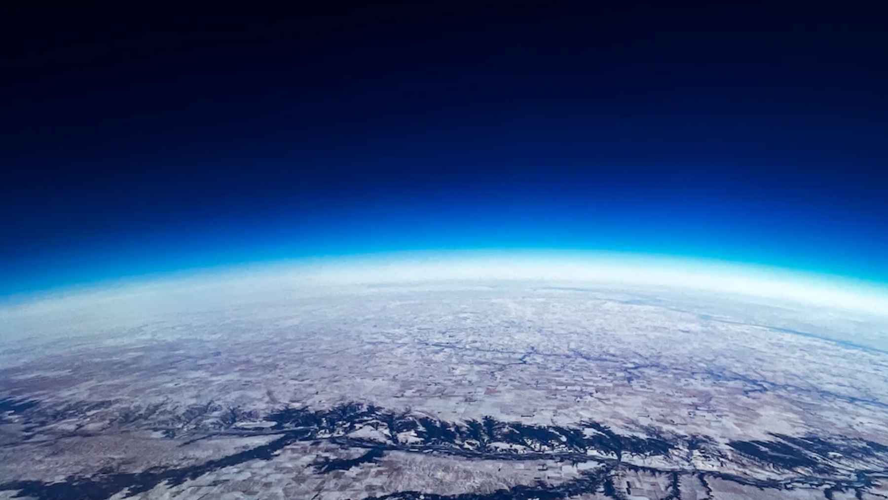 Vista de la Tierra desde el espacio, con el horizonte y la atmósfera azul sobre la superficie terrestre
