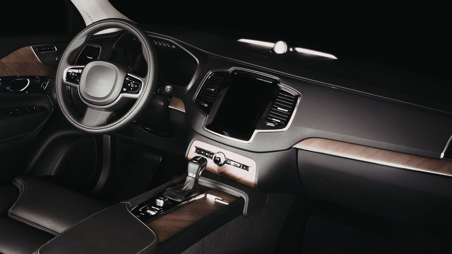 Interior de coche moderno con pantalla táctil central y mandos físicos en el salpicadero.