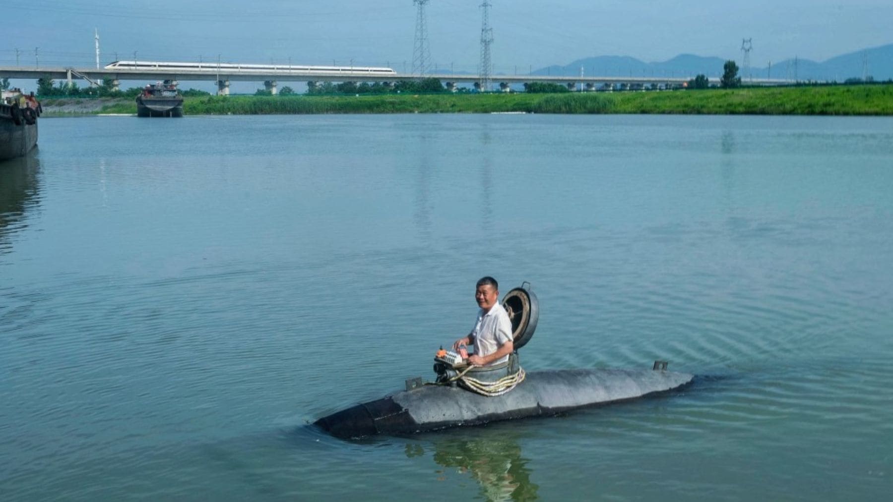 Agricultor chino probando su submarino casero Big Black Fish en un río.