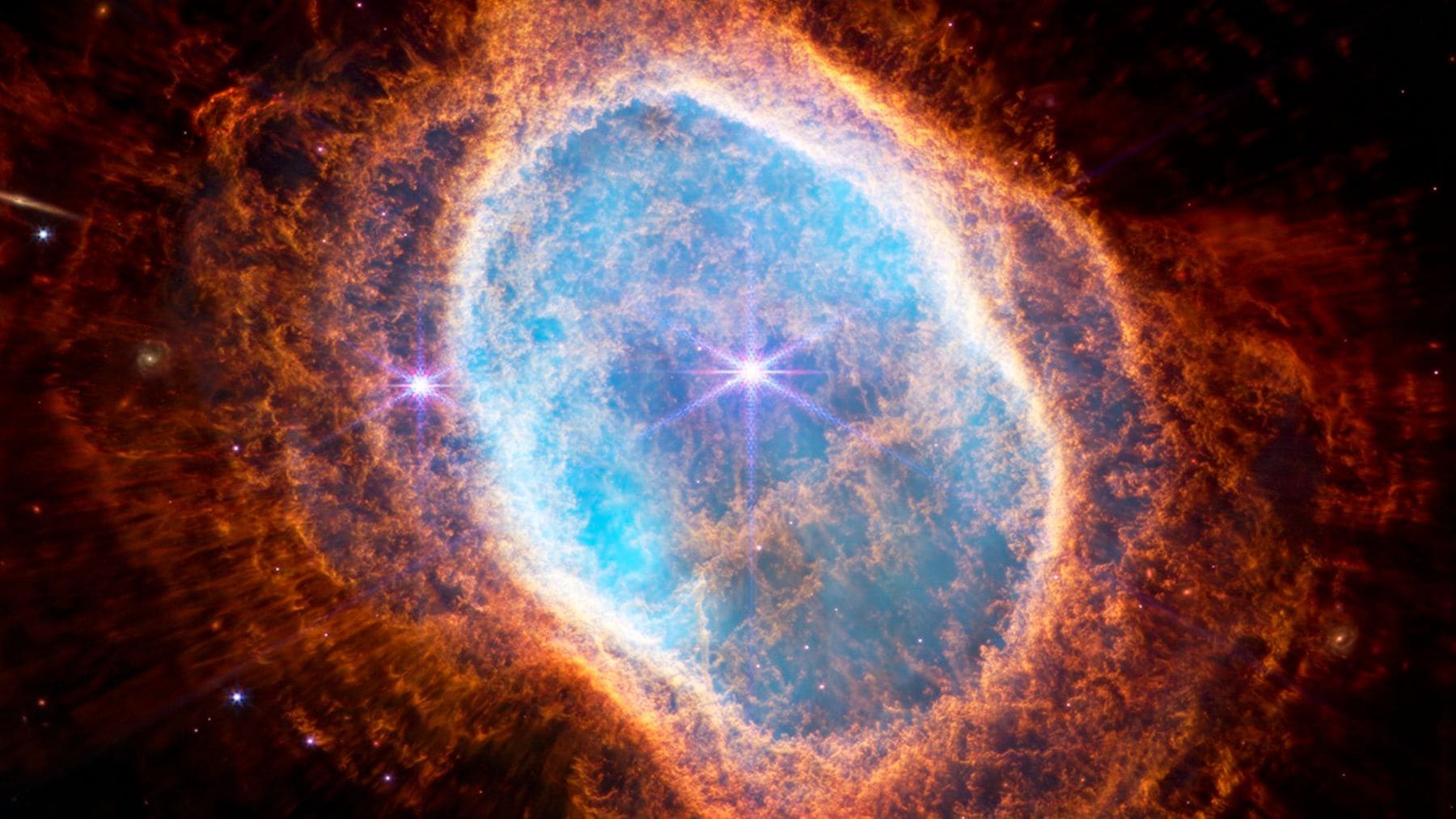 Imagen del telescopio James Webb mostrando una nebulosa con gas brillante asociada a agujeros negros jóvenes en el universo temprano.