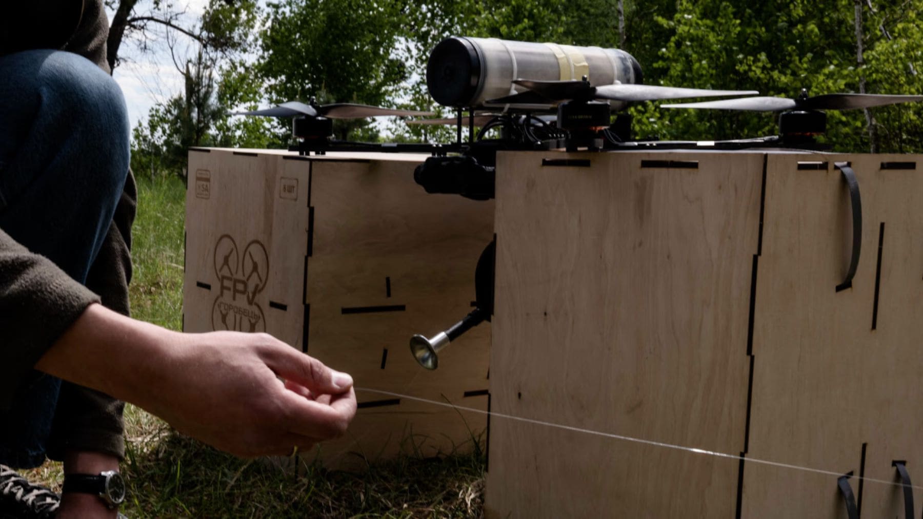Drone militar junto a equipo de comunicaciones oculto en el campo durante la guerra en Ucrania.