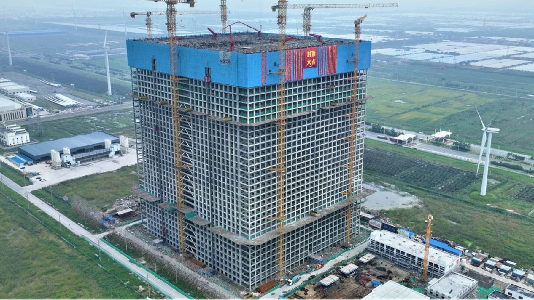 Torre de almacenamiento de energía por gravedad de Energy Vault en Rudong China con estructura industrial y grúas.