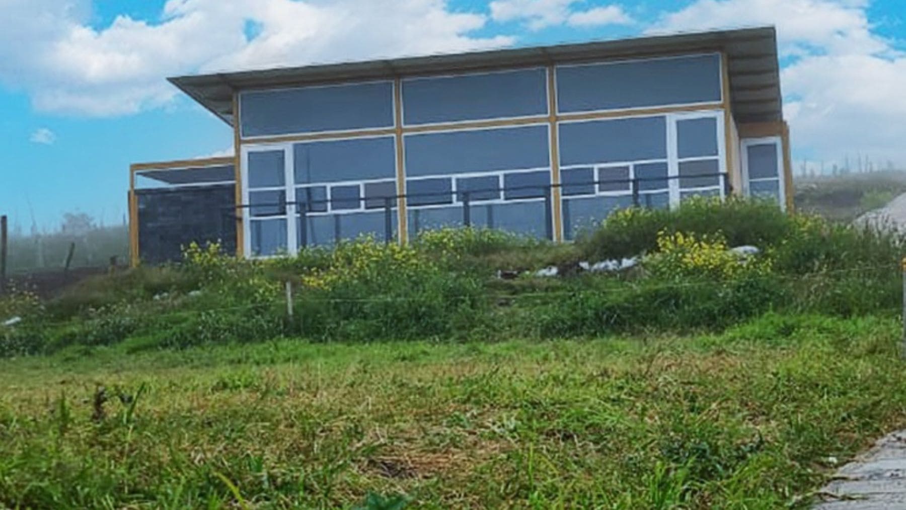 Casa construida con bloques de plástico reciclado sin cemento en entorno rural.
