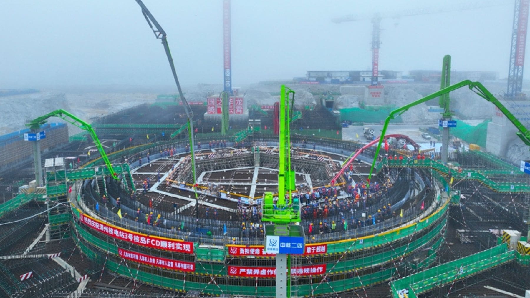 Construcción de reactor nuclear en China con grúas y cientos de trabajadores en una nueva central energética.