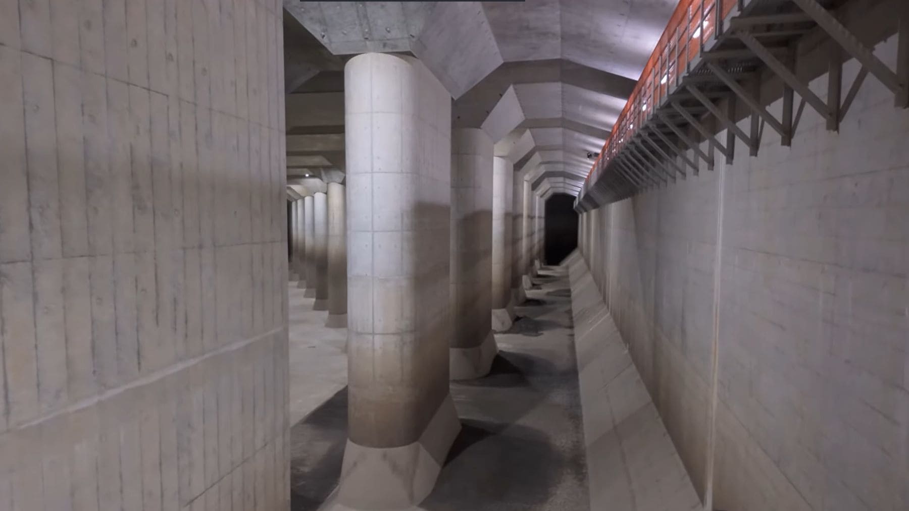 Interior de un sistema de drenaje subterráneo gigante con pilares, similar al proyecto de superembalse de Hanói.