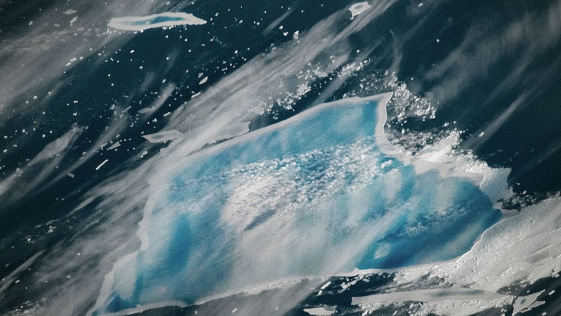 Iceberg A-23A con agua azul y grietas internas en el Atlántico Sur durante su desintegración.