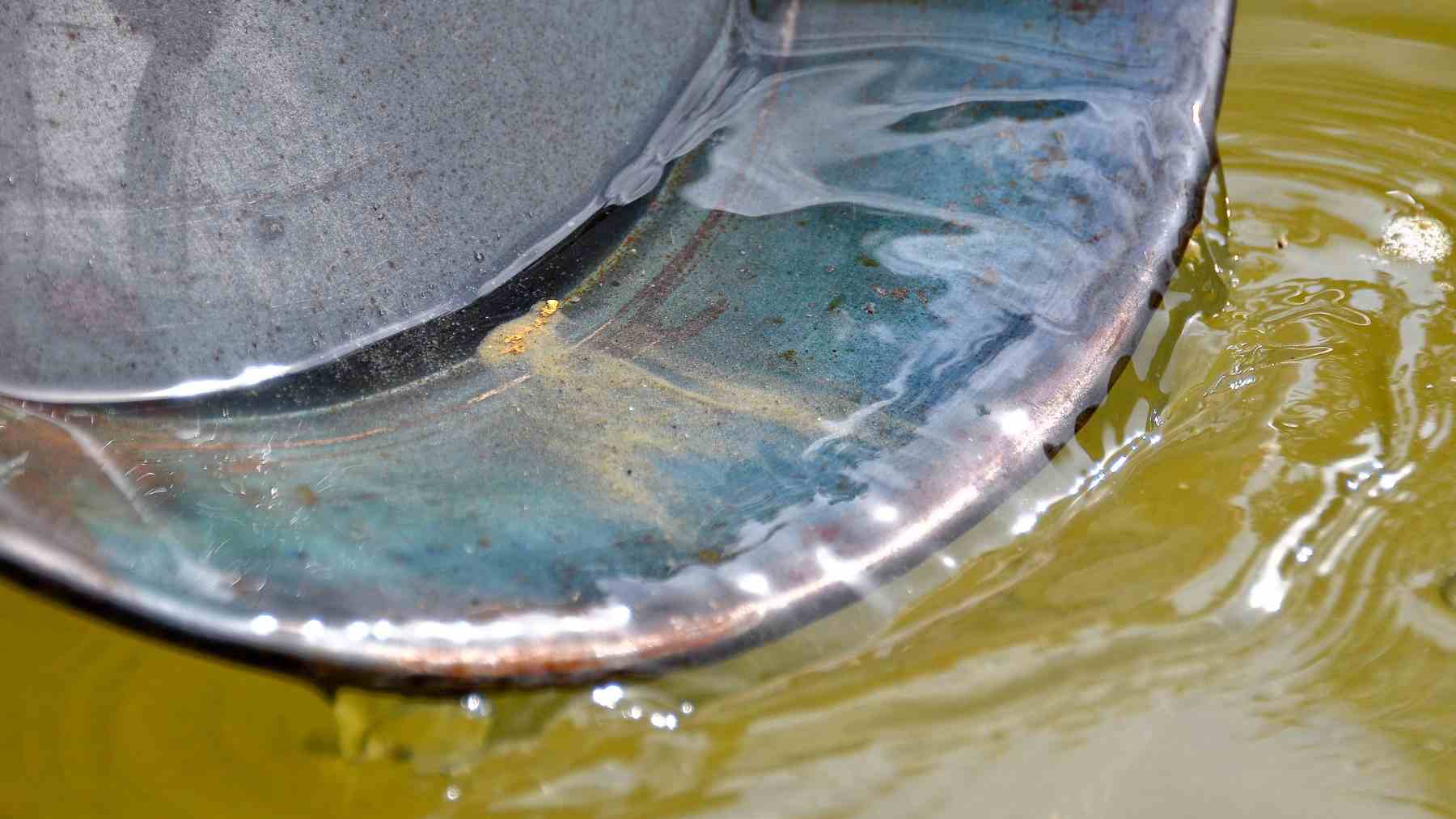 Partículas de oro en sedimentos durante proceso de formación natural en entorno acuático.