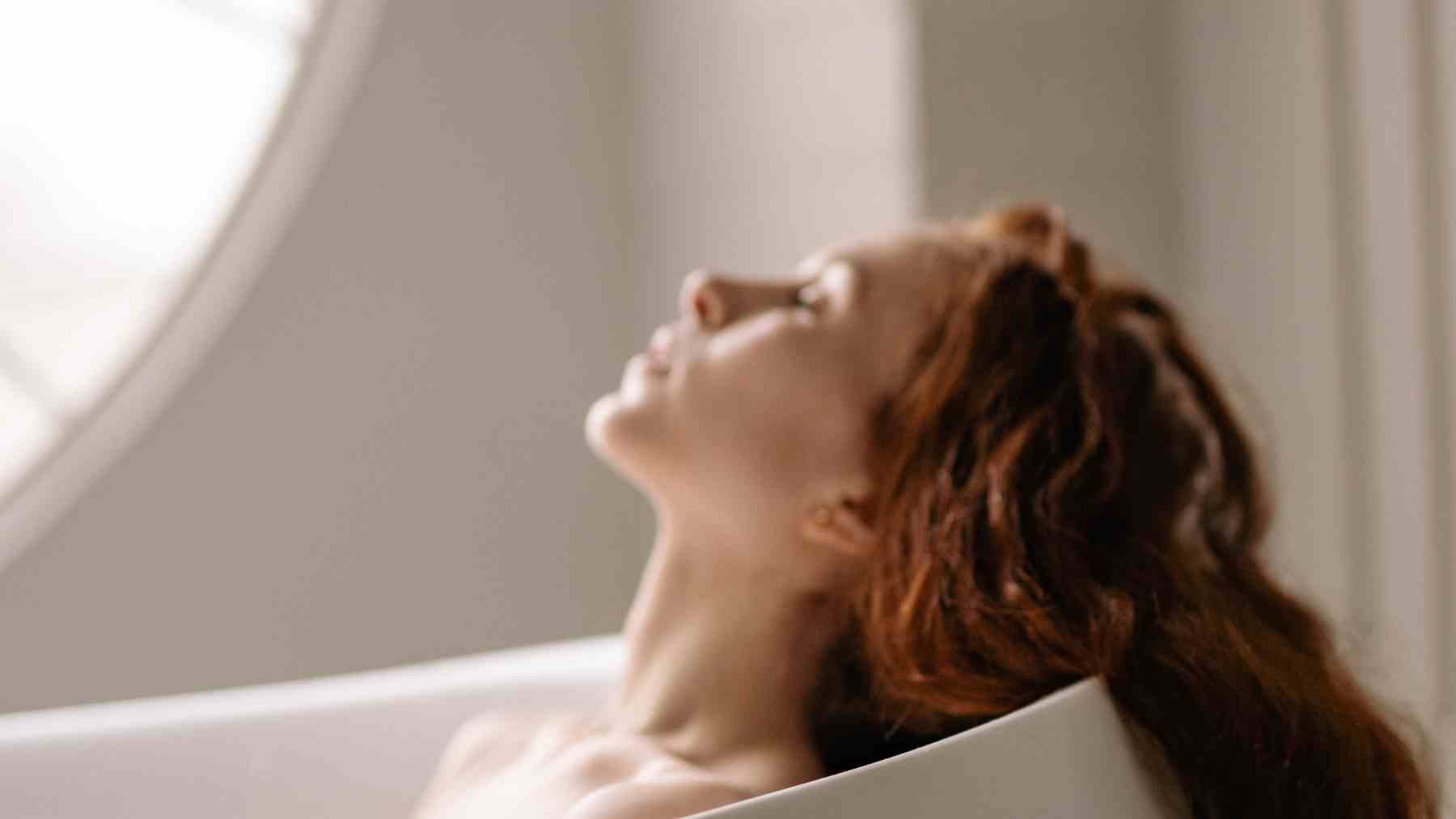 Mujer pelirroja con piel clara expuesta a la luz, ejemplo de rasgos ligados a la evolución genética humana.