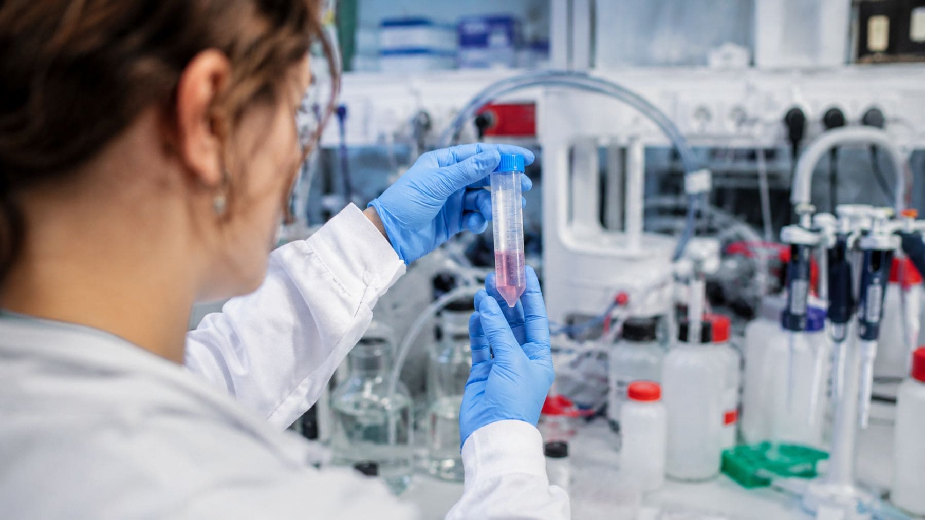 Investigadora trabajando con nanopartículas de platino en un laboratorio para mejorar la radioterapia contra el cáncer.