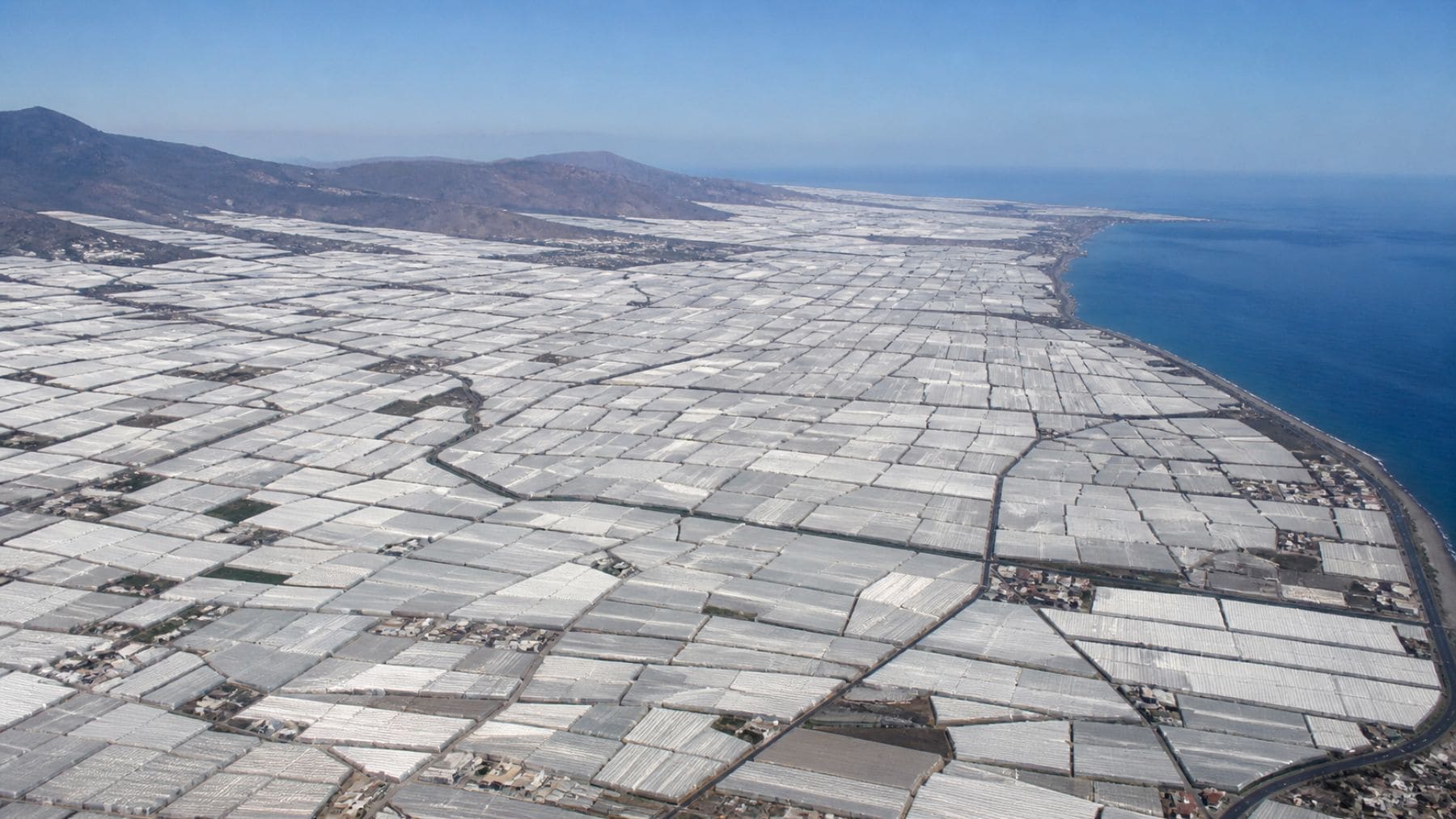 Vista aérea del mar de plástico de Almería con miles de invernaderos junto a la costa, imagen captada desde el espacio.