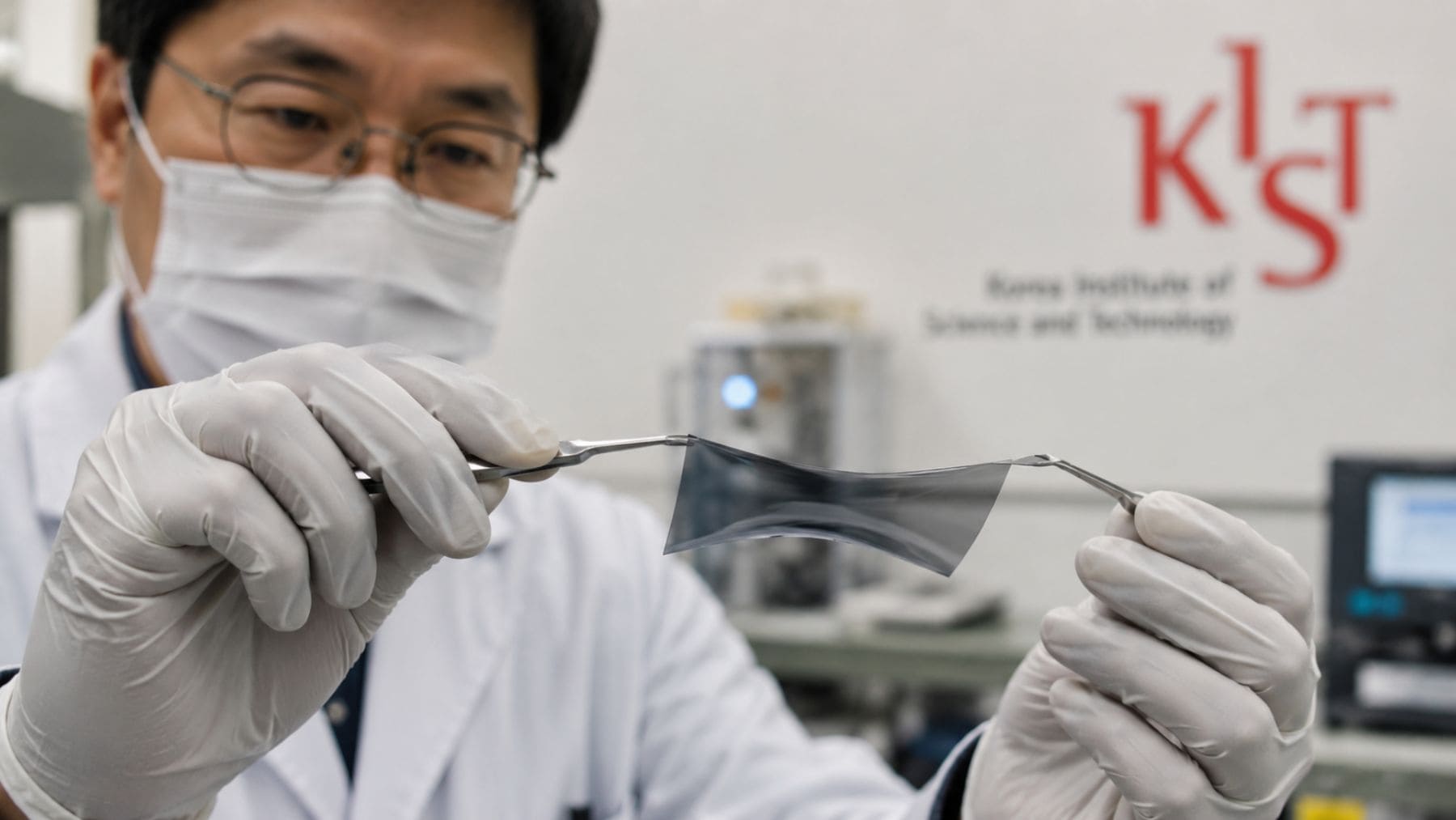 Investigador del KIST sostiene un material flexible capaz de bloquear ondas electromagnéticas y radiación.