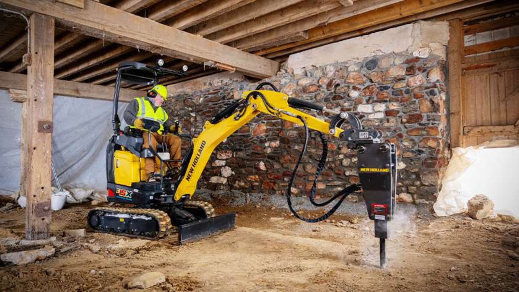 Miniexcavadora eléctrica New Holland E25X trabajando en una obra interior sin emisiones contaminantes.