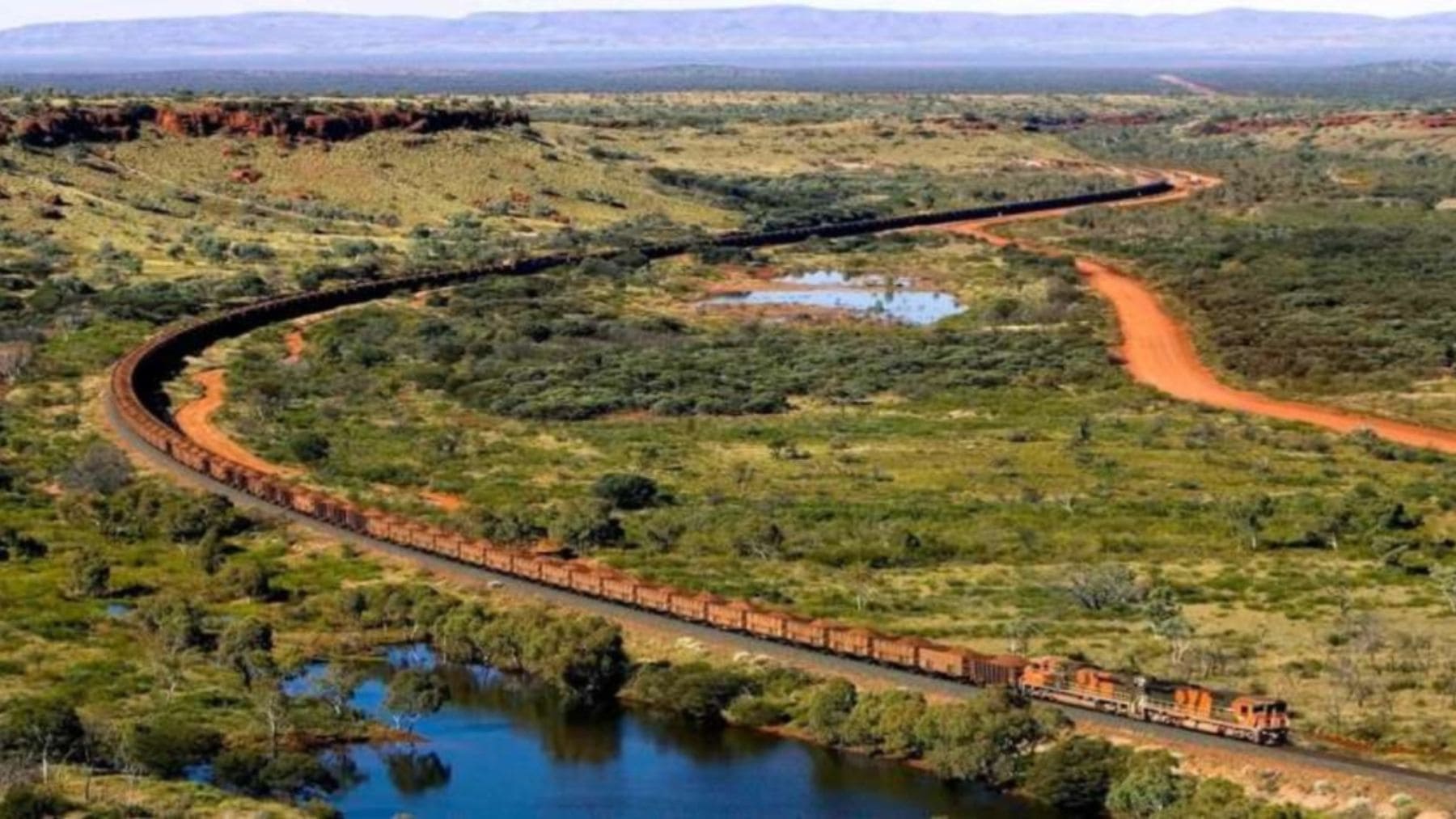 El tren más largo del mundo recorriendo el desierto de Australia con cientos de vagones de mineral de hierro.