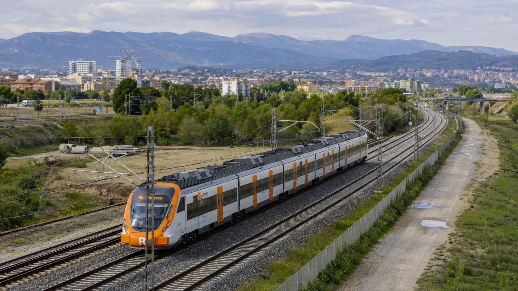 Tren de Rodalies circulando por la futura línea orbital ferroviaria de Cataluña.