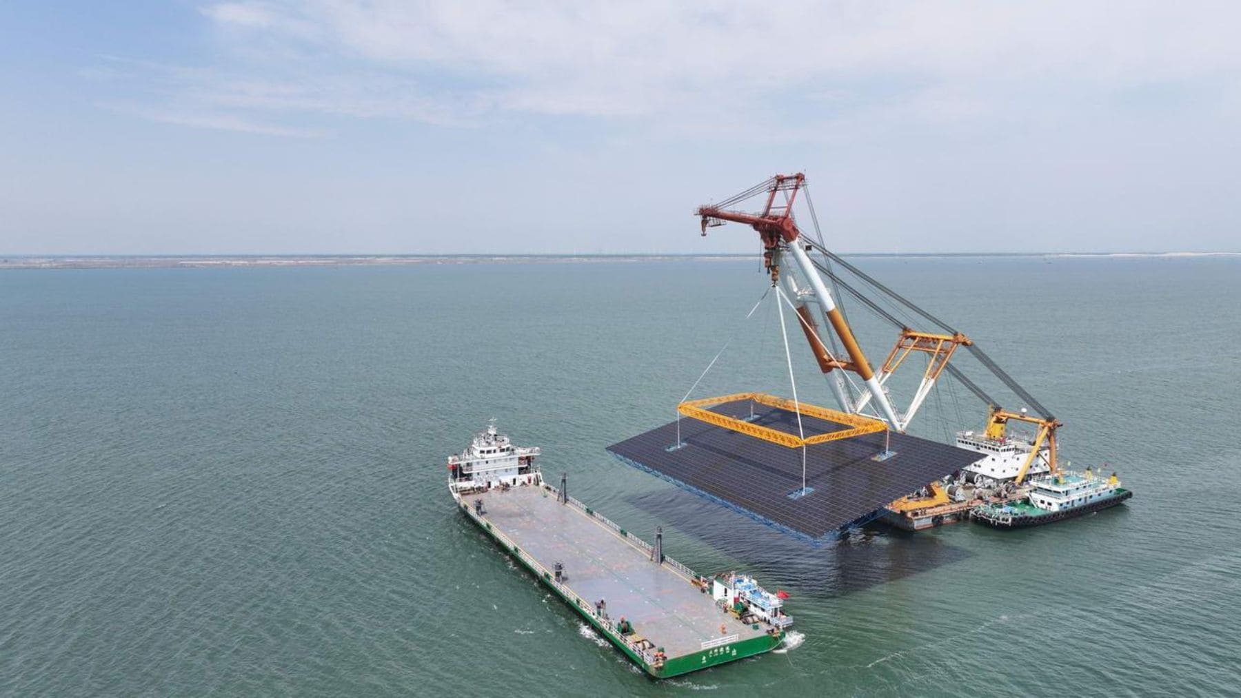 Grúa instalando una estructura fotovoltaica en el parque solar marino de Changli, China, sobre pilotes de acero en el mar de Bohai
