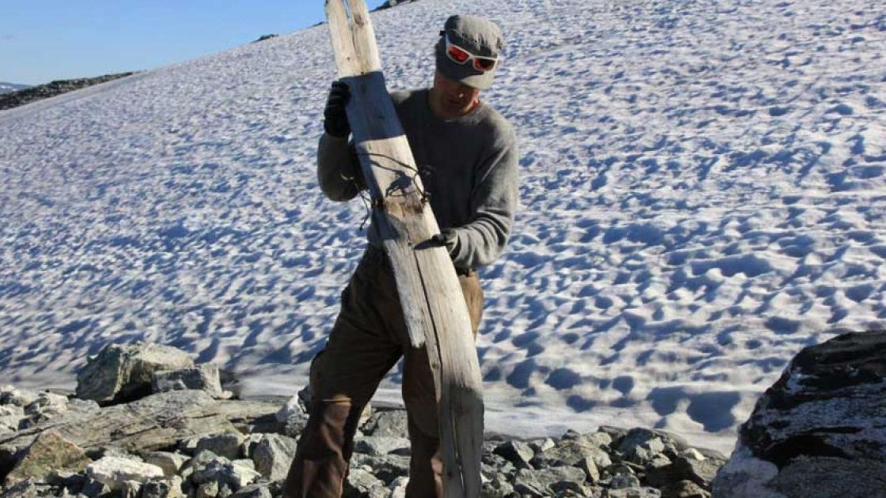 Arqueólogo sostiene un esquí prehistórico de 1.300 años hallado tras el deshielo de un glaciar en Noruega.