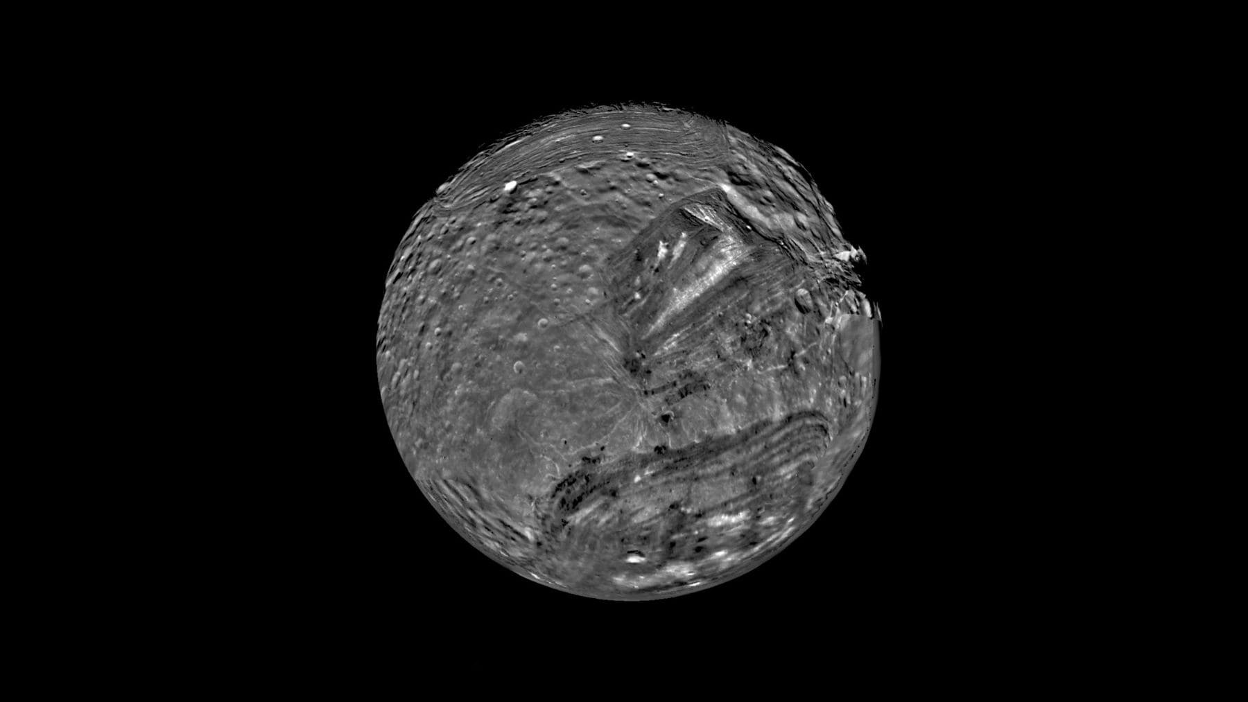 Miranda, luna de Urano fotografiada por la Voyager 2 de la NASA con enormes fracturas y regiones geológicas complejas.