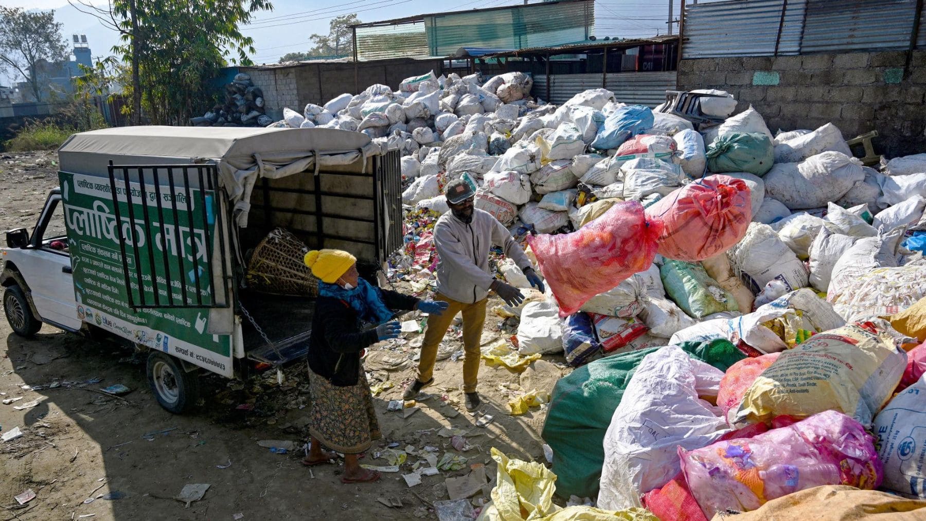 Trabajadores clasifican residuos plásticos en una planta de reciclaje de Pokhara, Nepal, para fabricar carreteras sostenibles.