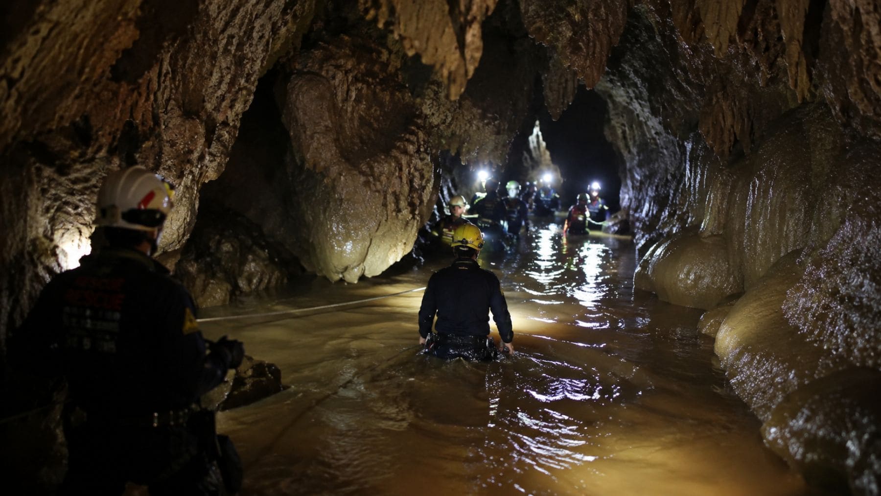 Rescatistas avanzan por una cueva inundada durante la operación para salvar a varios hombres atrapados en Laos.