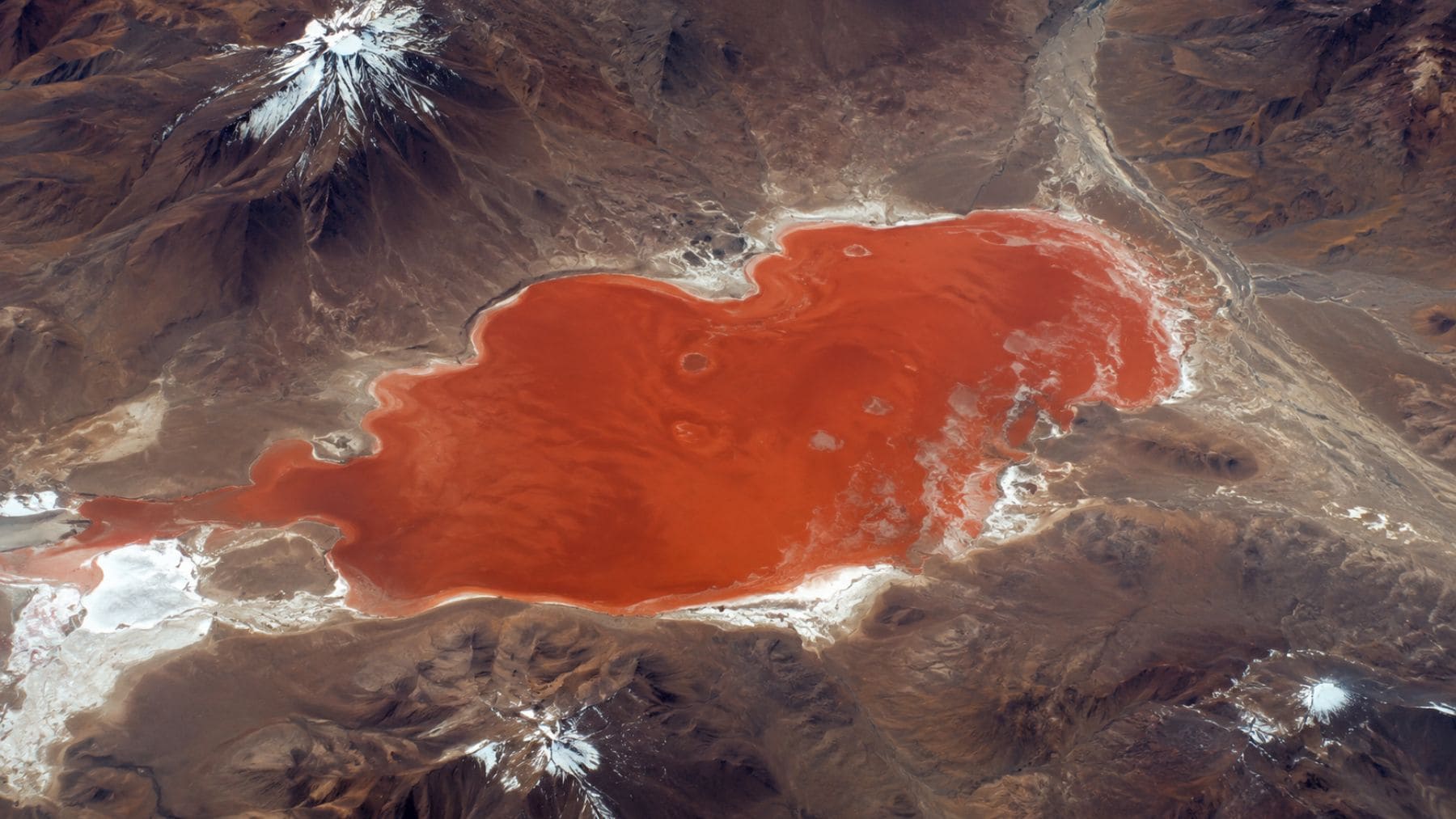 Vista aérea de la Laguna Colorada en Bolivia captada desde la Estación Espacial Internacional con sus característicos tonos naranjas y rojizos