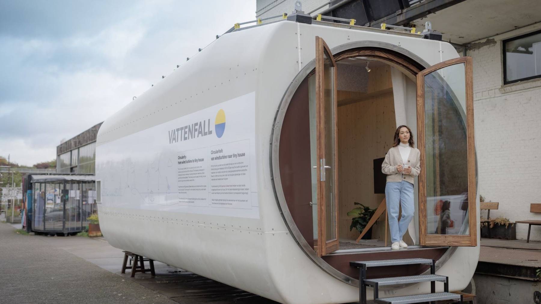 Minicasa construida dentro de la góndola de un aerogenerador retirado, con una puerta redonda de madera abierta