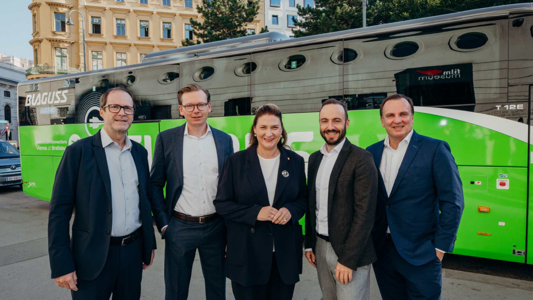 Cinco personas posan delante de un autocar eléctrico verde de FlixBus autocares eléctricos