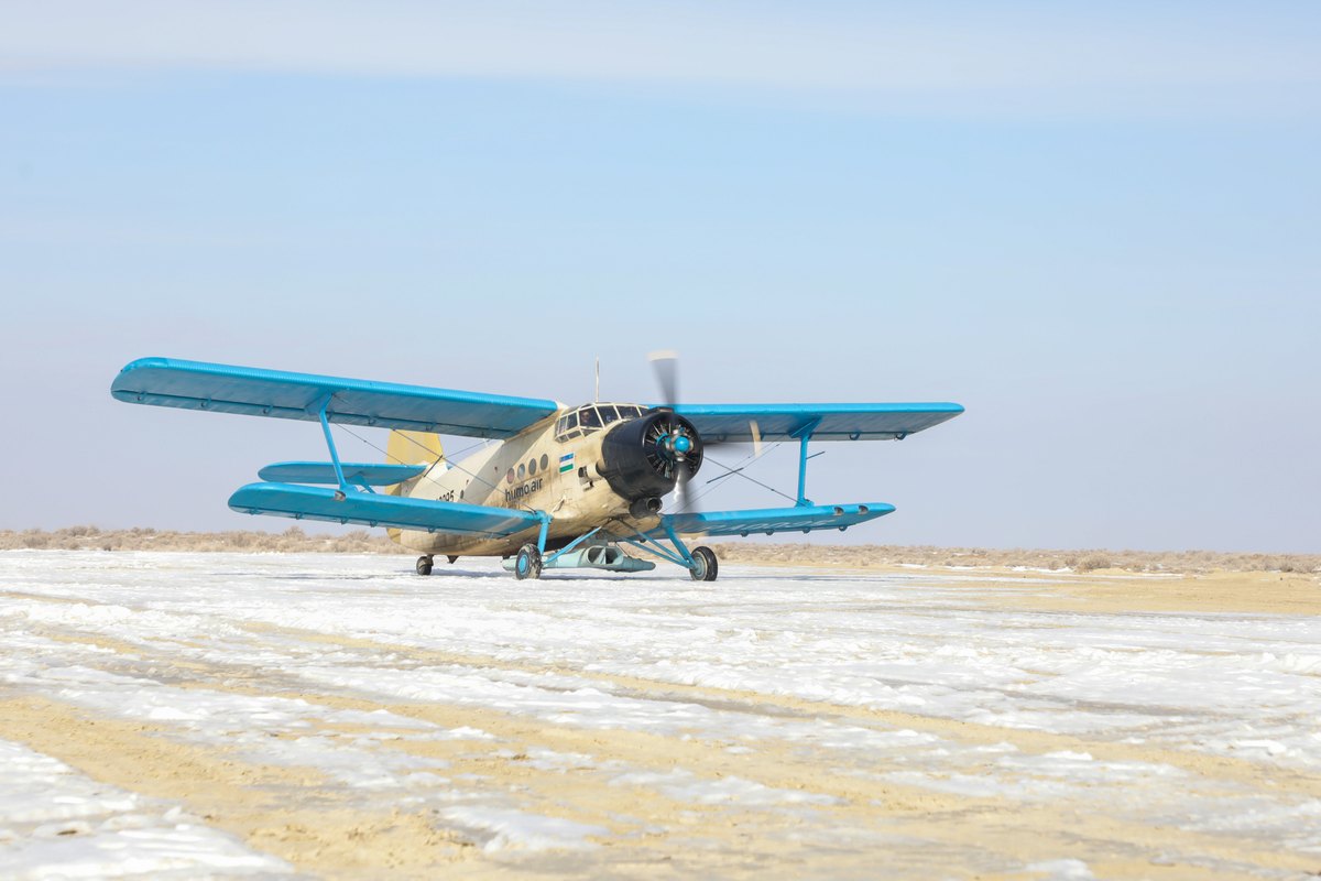 Avioneta biplano AN-2 sobre el lecho seco del mar de Aral, cubierto en parte de nieve