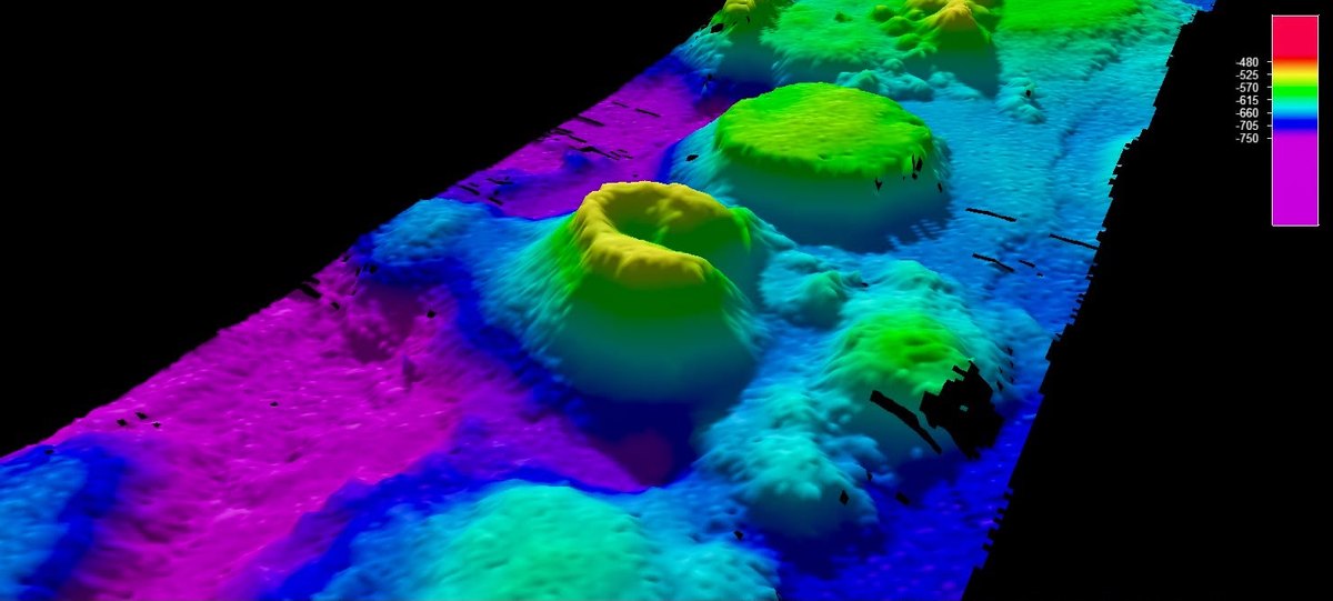 Modelo batimétrico en 3D de un volcán submarino con caldera y montes cercanos en el mar de Groenlandia, coloreado según la profundidad