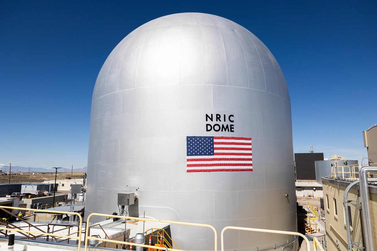 Cúpula plateada del banco de pruebas DOME del NRIC, con una bandera de EE. UU. en la fachada, en el Laboratorio Nacional de Idaho