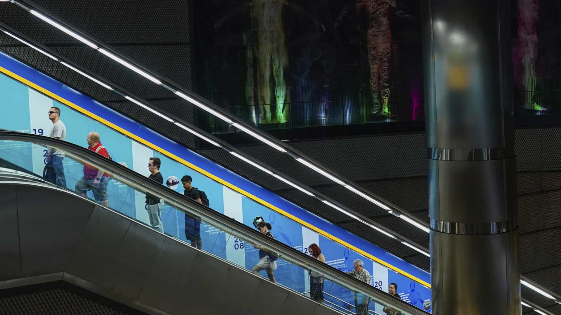 Viajeros en una de las escaleras mecánicas de una estación de Metro de Madrid