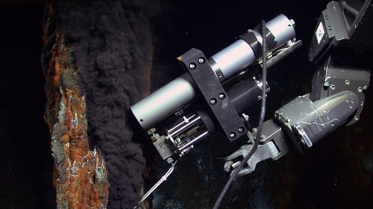 Brazo del robot submarino Jason junto a una chimenea hidrotermal negra a 5000 metros de profundidad en el campo Piccard