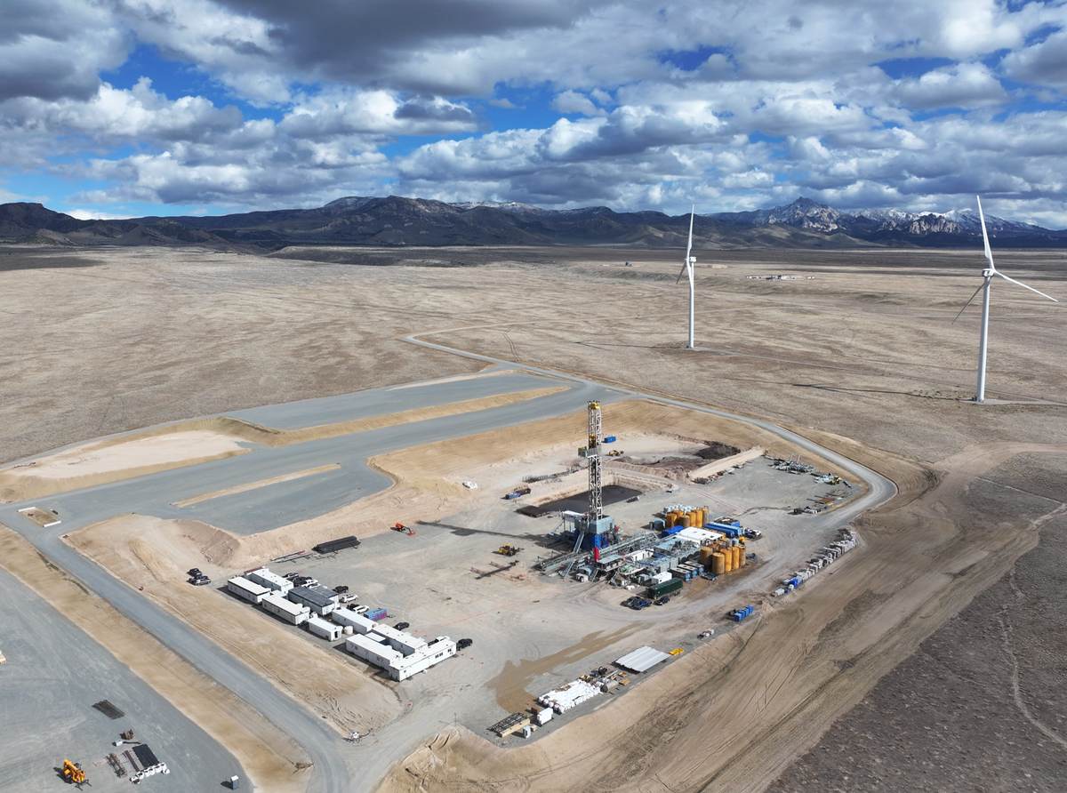 Torre de perforación en una plataforma de Cape Station, en Utah, rodeada de desierto y aerogeneradores
